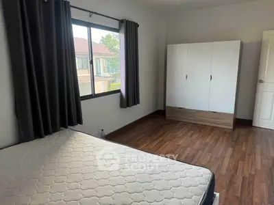 Spacious bedroom with large window and wardrobe, perfect for natural light lovers.