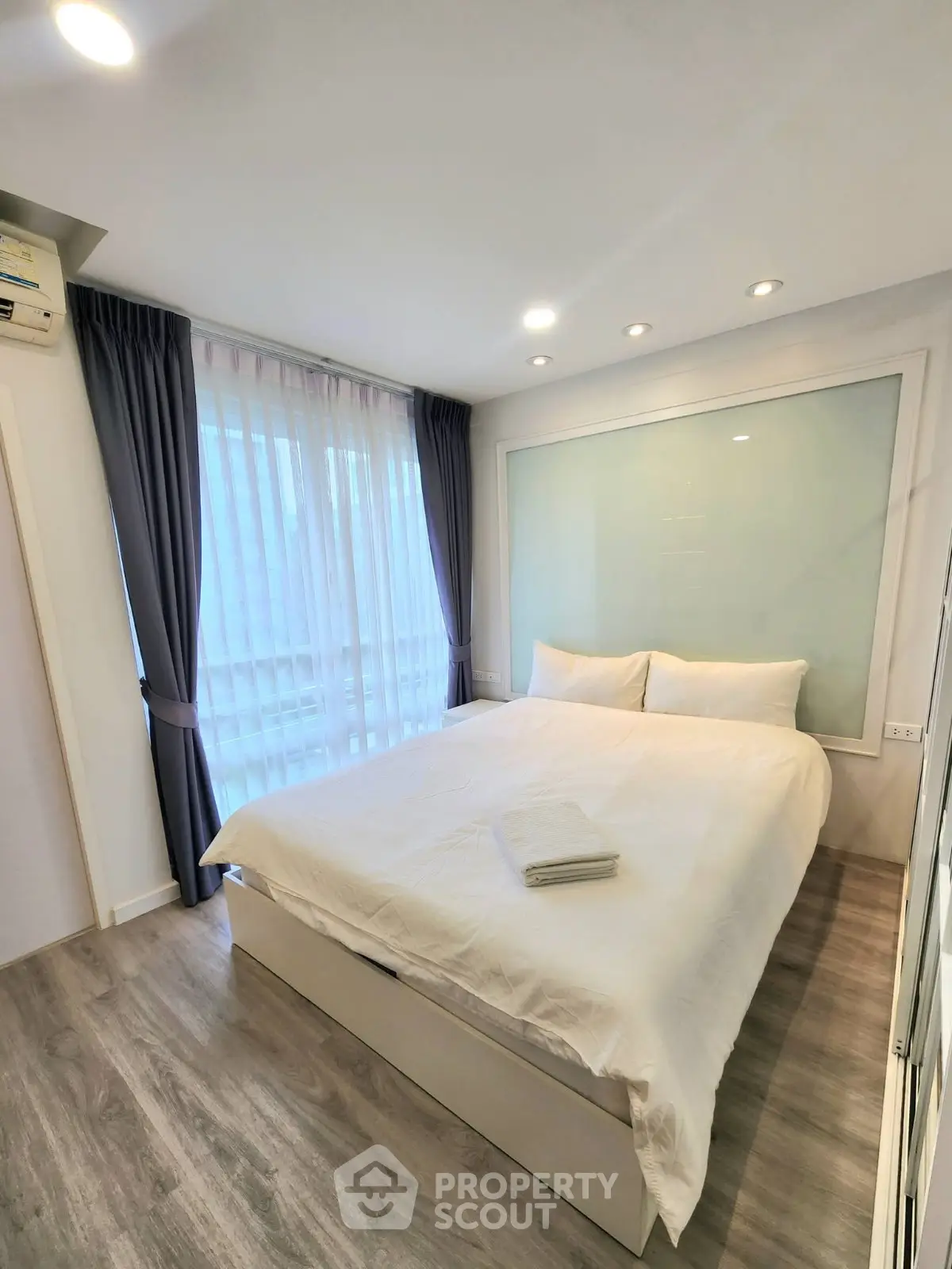 Modern bedroom with large window and elegant decor in a stylish apartment.