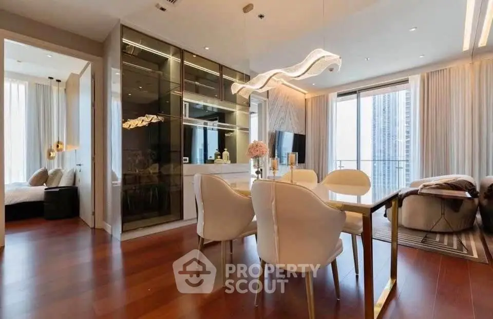 Luxurious modern living room with elegant dining area and city view balcony, featuring stylish lighting and hardwood floors.