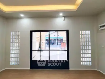Spacious room with large window and modern lighting, perfect for natural light lovers.