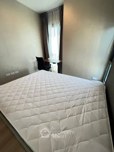 Cozy bedroom with natural light and workspace, ideal for modern living.