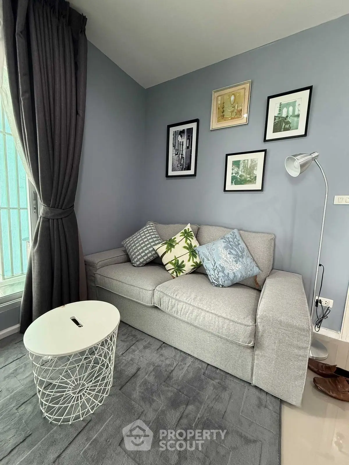 Cozy living room with stylish gray sofa and decorative pillows, perfect for relaxation.