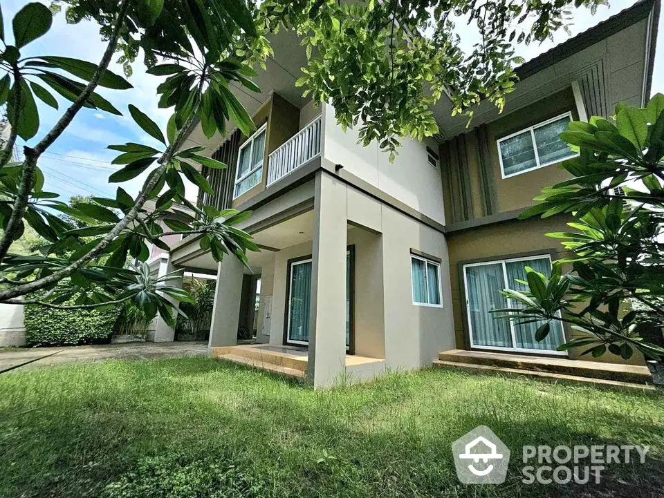 Modern two-story house with lush garden and large windows