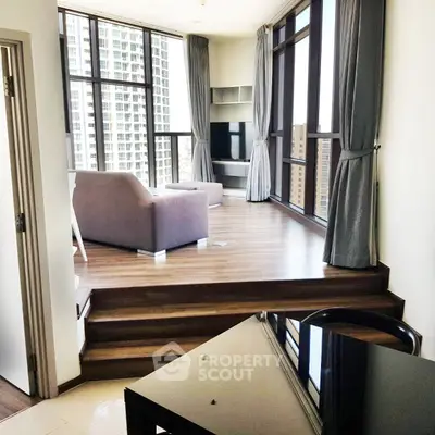 Modern living room with floor-to-ceiling windows and stylish furniture in a high-rise apartment.
