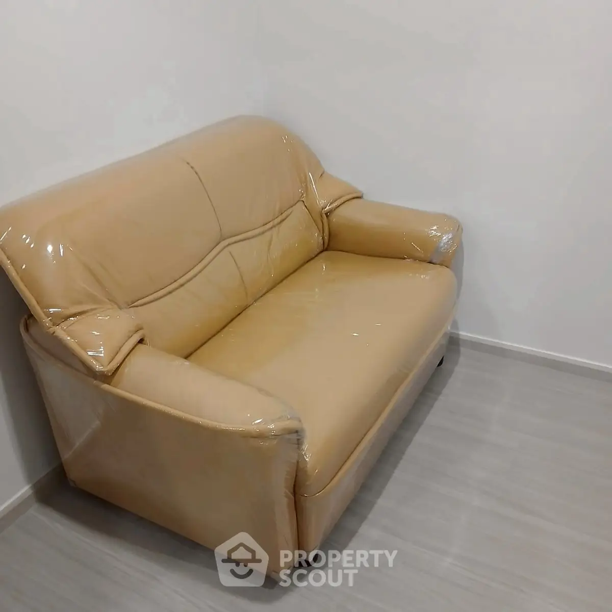 Cozy beige sofa in minimalist living room corner with sleek flooring.