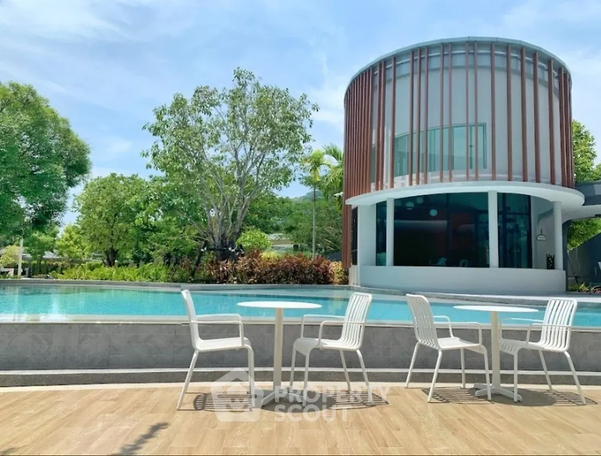 Luxurious modern villa with poolside seating and lush greenery, perfect for relaxation and entertainment.