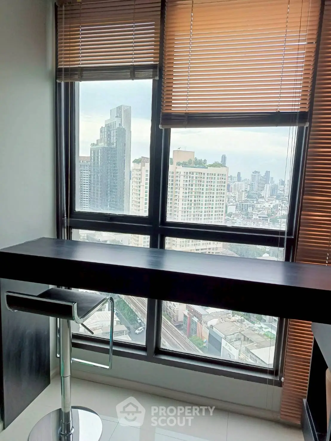 Modern high-rise apartment with stunning city view and sleek interior design.