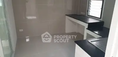 Modern kitchen with sleek countertops and tiled walls, featuring a compact and efficient layout.