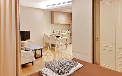 Cozy studio apartment with open kitchen and living area, featuring modern furnishings and warm lighting.