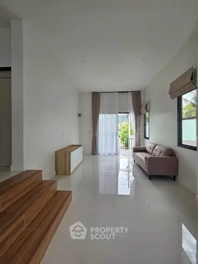Spacious living room with modern decor and large windows for natural light