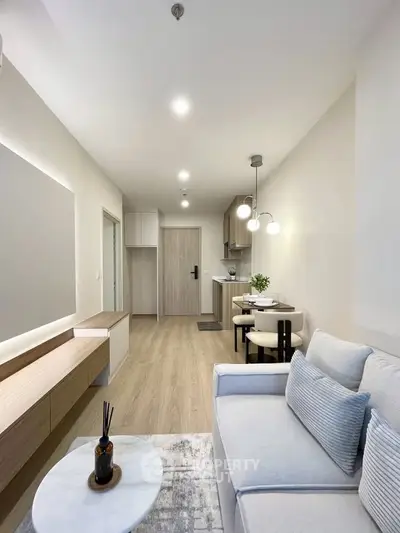 Modern living room with cozy seating and stylish dining area in open layout apartment.