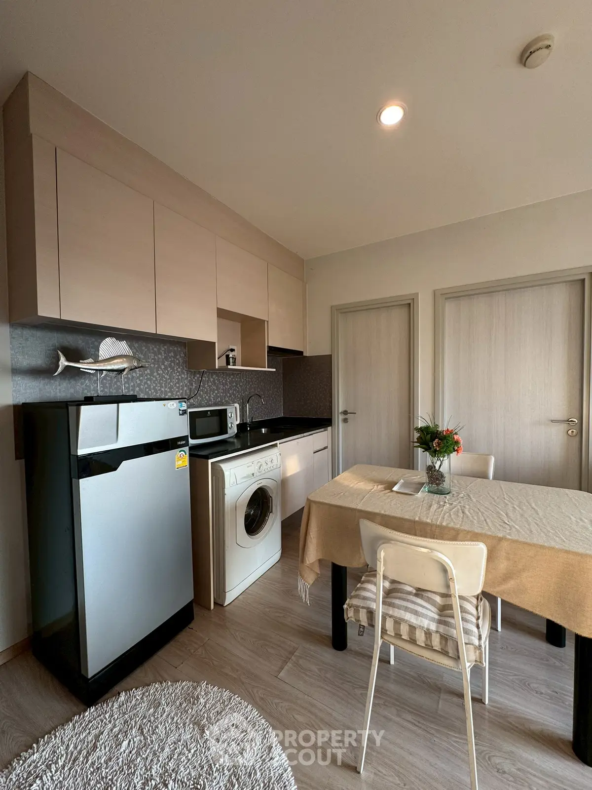 Modern kitchen with dining area, featuring sleek appliances and stylish cabinetry.