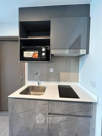 Modern compact kitchen with sleek cabinetry and built-in appliances