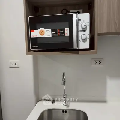 Modern kitchen with microwave and sleek sink design