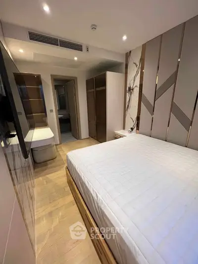 Modern bedroom with stylish decor and ample storage in a luxury apartment.