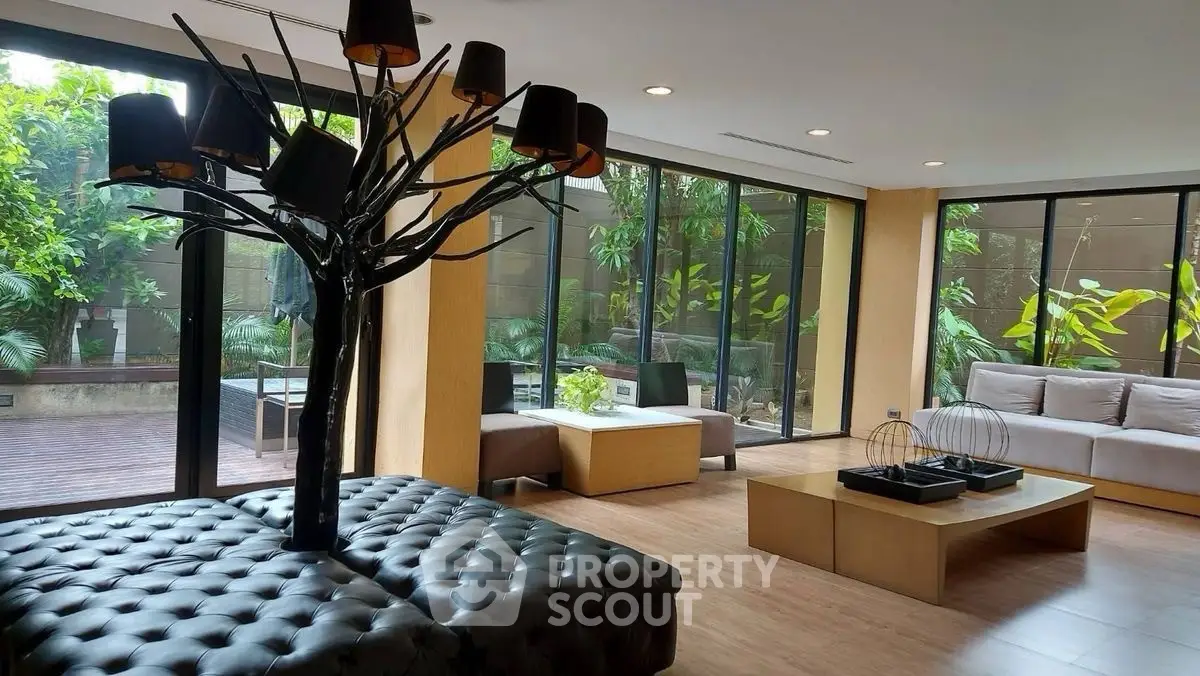 Luxurious living room with modern decor and large windows overlooking a lush garden.