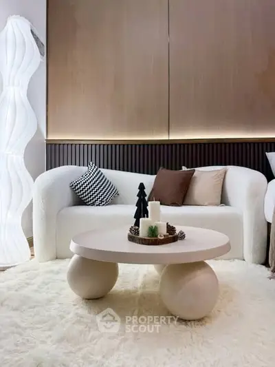 Stylish modern living room with cozy white sofa and unique round coffee table.