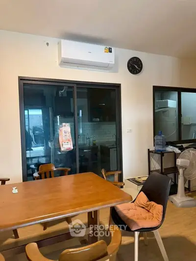 Cozy dining area with wooden table and chairs, adjacent to a modern kitchen.