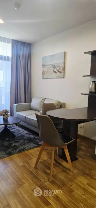 Modern living room with stylish decor and wooden flooring, featuring a cozy sofa and dining area.