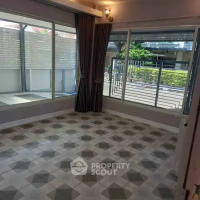 Spacious corner unit with large windows and stylish tile flooring, offering abundant natural light and outdoor views.