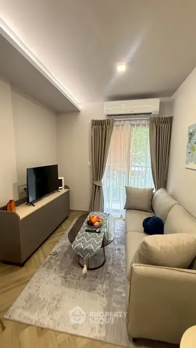 Cozy living room with modern decor, featuring a comfortable sofa, flat-screen TV, and elegant curtains.