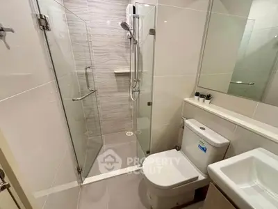 Modern bathroom with glass shower and sleek fixtures in a contemporary apartment.