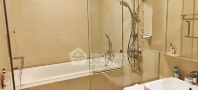 Modern bathroom with glass shower and bathtub in a stylish apartment.