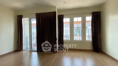 Spacious empty room with large windows and wooden flooring, ideal for customization.
