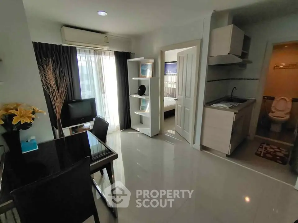 Modern apartment interior with open layout, featuring a compact kitchen and cozy living area.