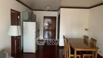 Spacious dining area with wooden furniture and modern kitchen appliances in a cozy apartment.