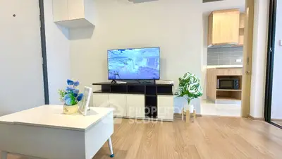 Modern living room with sleek TV setup and stylish decor in a cozy apartment.