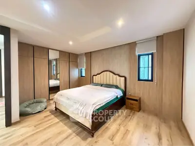 Spacious bedroom with elegant wooden flooring and modern decor