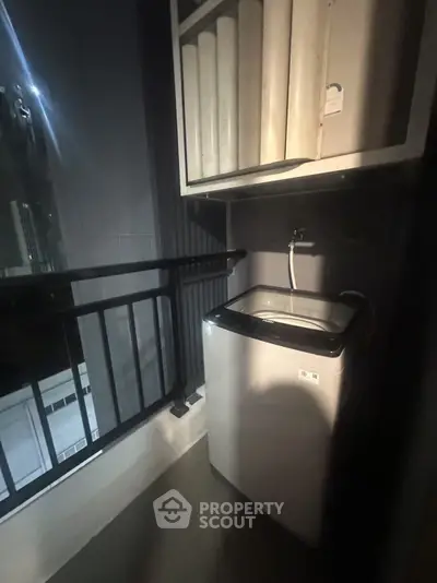 Compact balcony with washing machine and storage shelves, ideal for urban living.