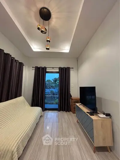 Modern living room with stylish lighting and sleek furniture, featuring a cozy sofa and entertainment unit.