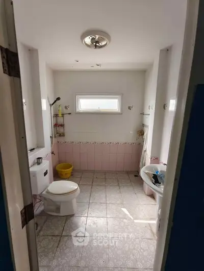 Spacious bathroom with natural light and tiled flooring