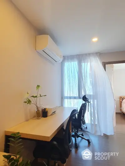 Modern study room with desk, chairs, and natural light from large window