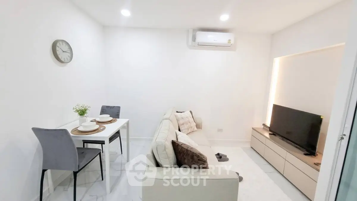 Modern living room with sleek furniture and minimalist decor, featuring a cozy sofa and dining area.