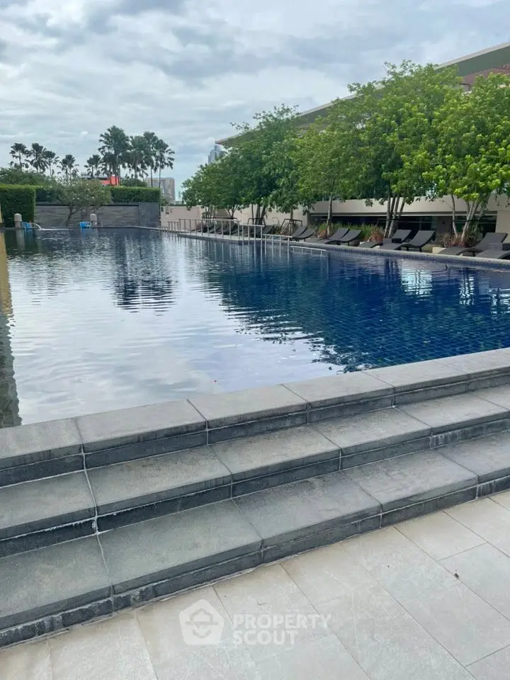 Luxurious outdoor pool area with serene surroundings and lush greenery, perfect for relaxation and leisure.