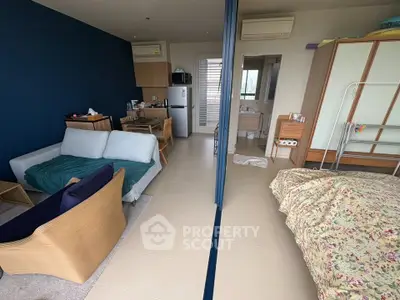 Modern studio apartment with open layout, featuring cozy living area and compact kitchen.