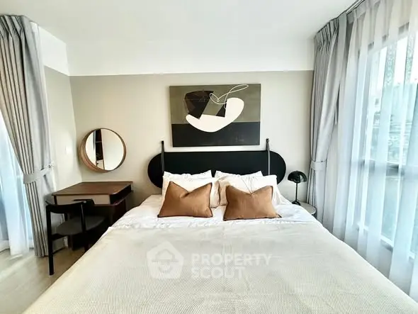 Modern bedroom with stylish decor and large windows for natural light.