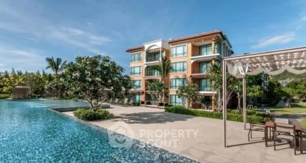 Luxurious apartment complex with stunning pool and lush garden surroundings.