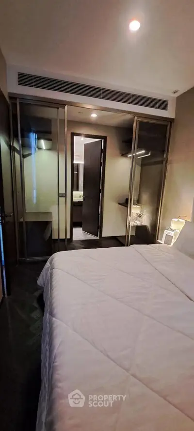 Modern bedroom with glass partitions and cozy lighting