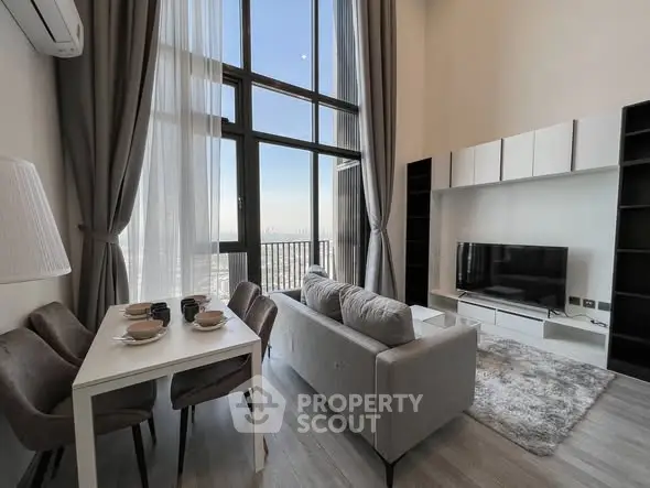 Modern living room with high ceilings and large windows offering stunning city views.