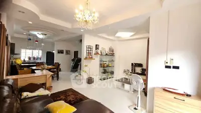 Spacious living room with elegant chandelier and modern decor in a cozy home setting.