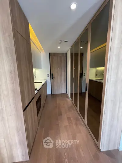 Modern kitchen with sleek wooden cabinetry and mirrored storage doors