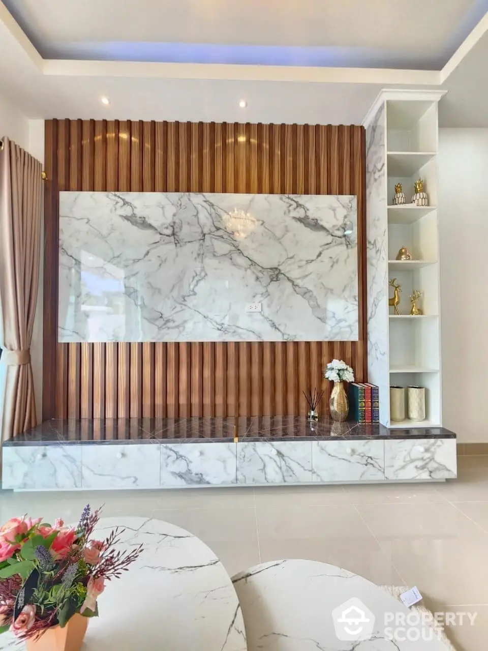 Luxurious living room with marble feature wall, elegant wooden accents, and built-in shelving, perfect for sophisticated decor.