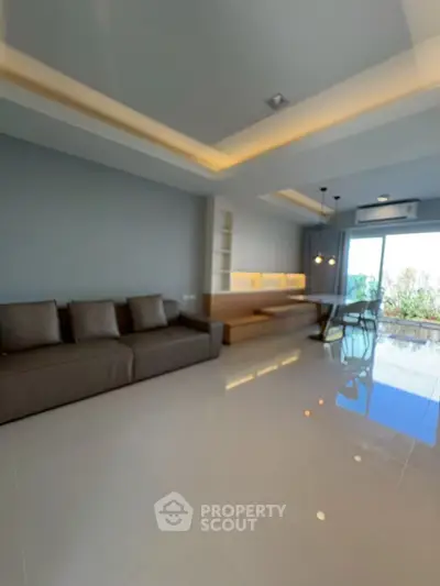 Spacious modern living room with sleek design and large windows offering natural light.