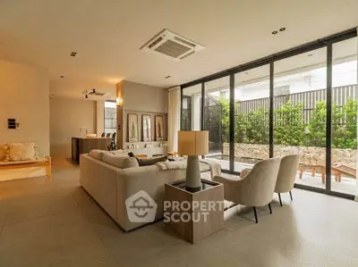 Spacious modern living room with large windows and elegant furniture, perfect for relaxation and entertaining.
