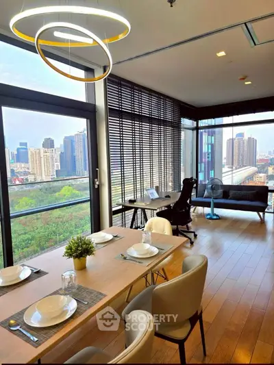 Modern dining and living area with city view, featuring stylish furniture and floor-to-ceiling windows.