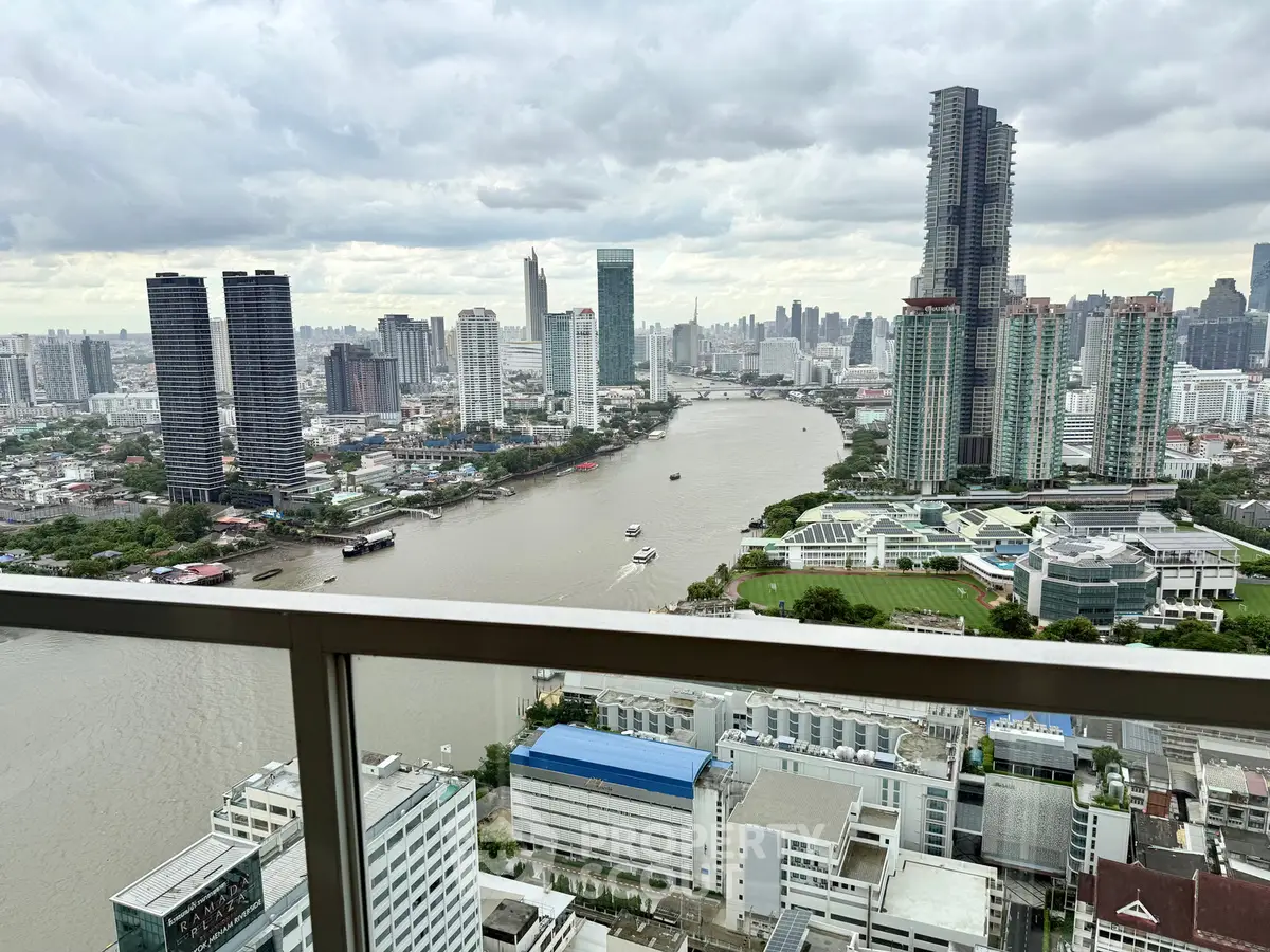 Stunning cityscape view from a high-rise balcony overlooking a river and modern skyline.